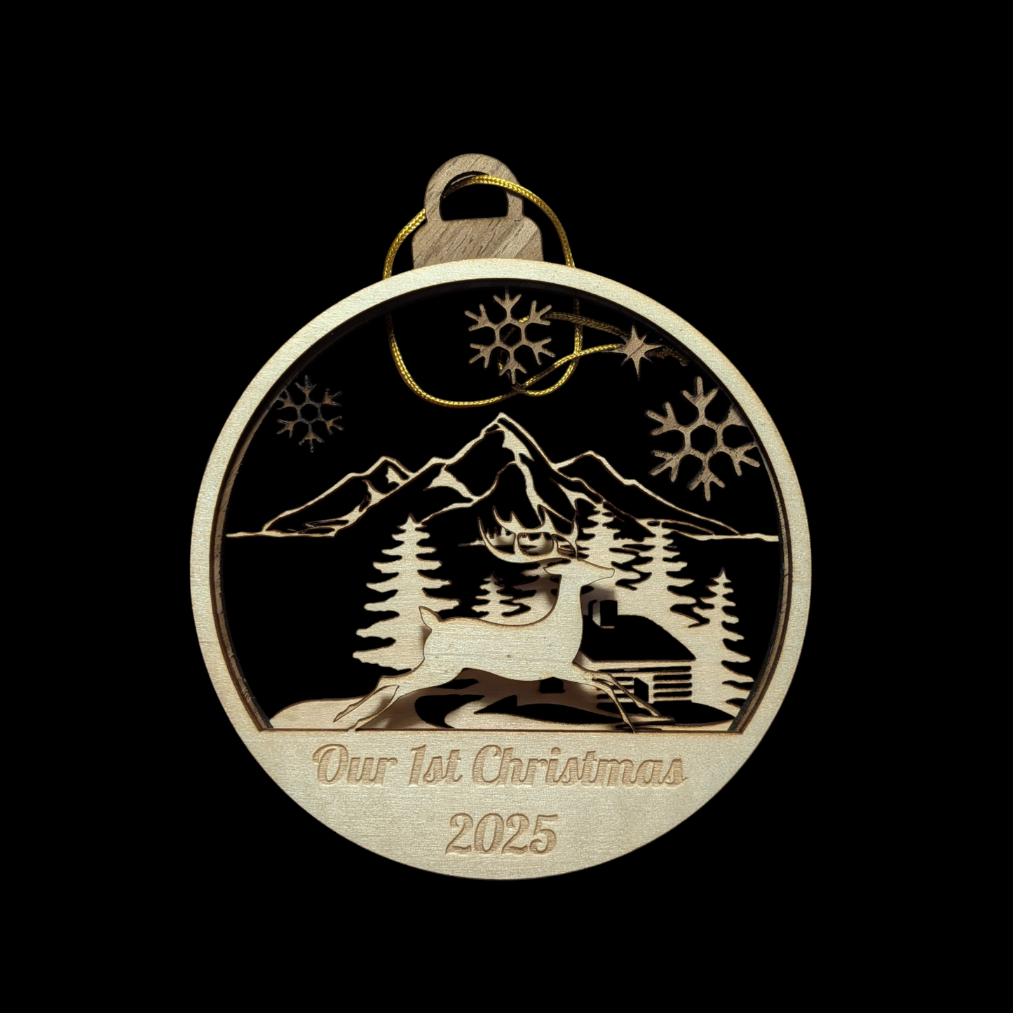 Decorative ornament with mountain and tree design, 'Our 1st Christmas 2025' text on a black background