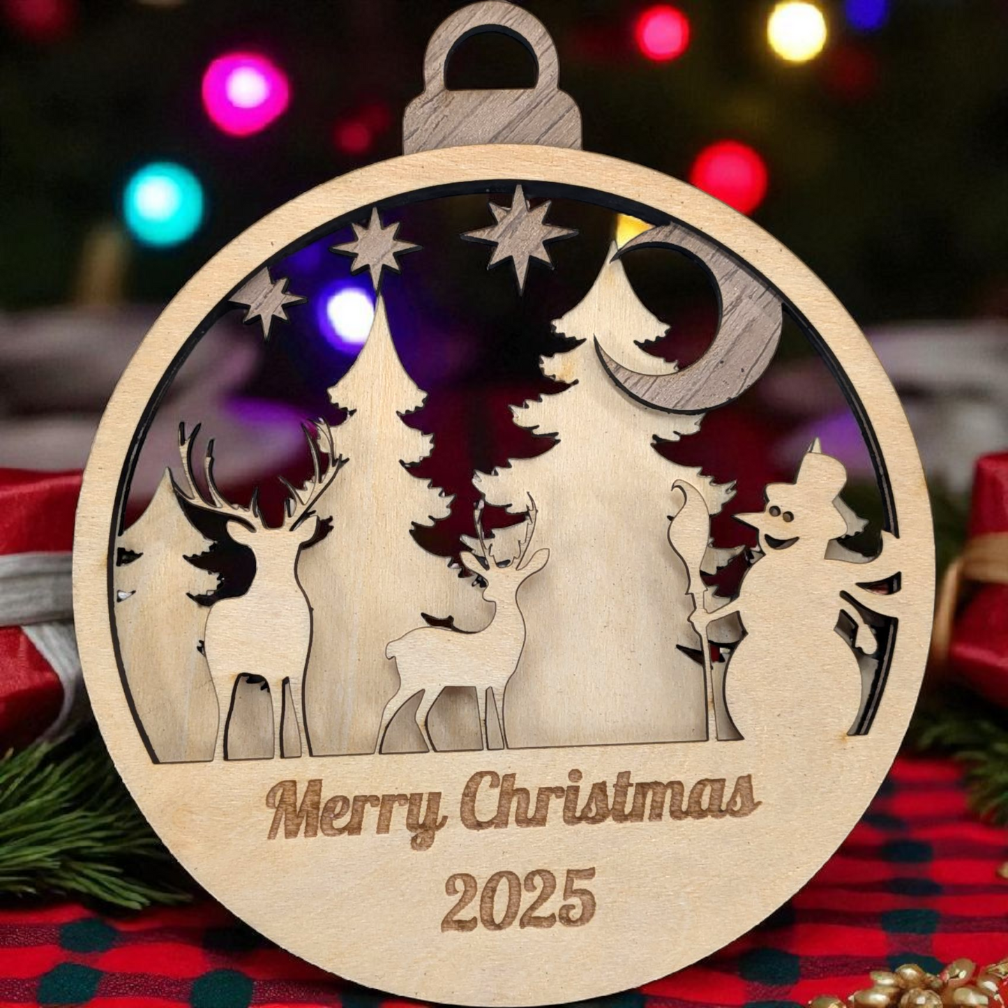 Wooden Christmas ornament with reindeer, trees, and snowman design, featuring 'Merry Christmas 2025' text.