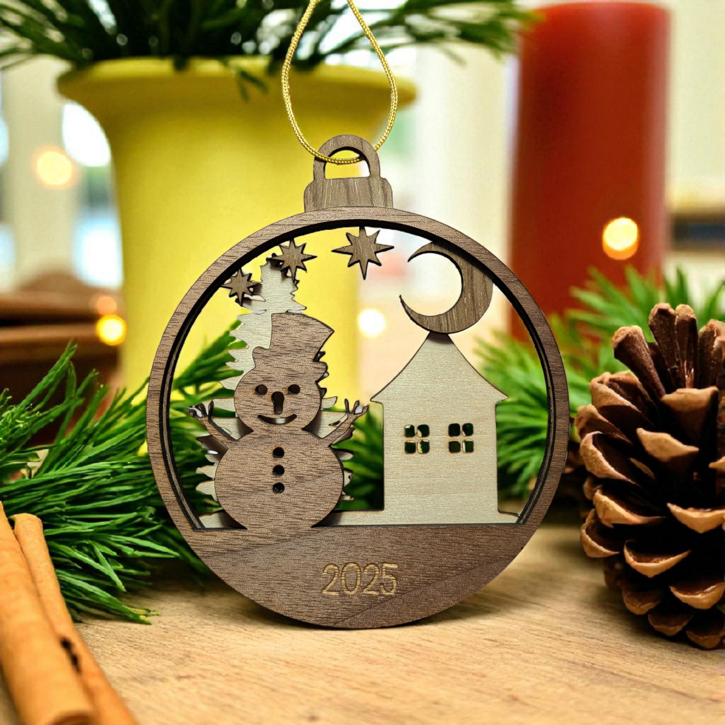 Wooden Christmas ornament with snowman and house design, featuring the year 2025, on a festive background.