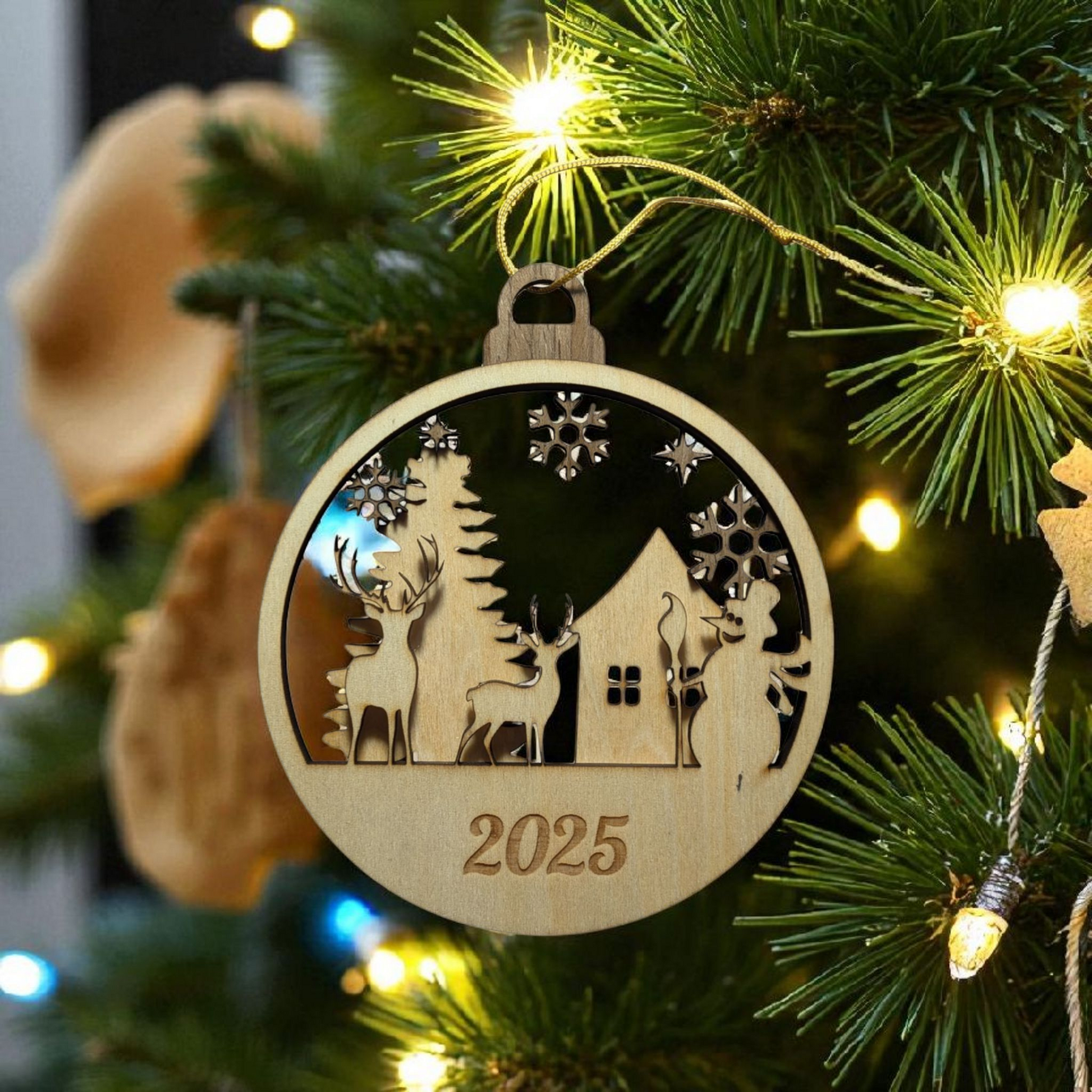 Wooden Christmas ornament with reindeer and house design on a lit Christmas tree.